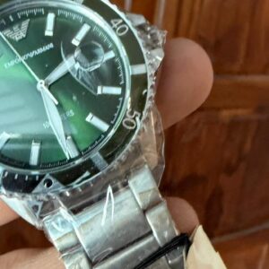 Emporio Armani AR11338 green dial close-up showing hour markers, hands, and date window