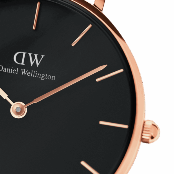 Close-up of black dial with rose gold indexes and hands, DW logo visible