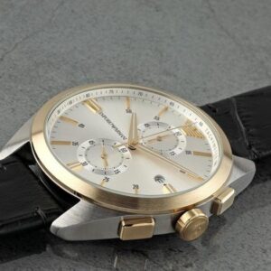 Emporio Armani Claudio chronograph on wrist showing white dial with gold accents and black leather strap