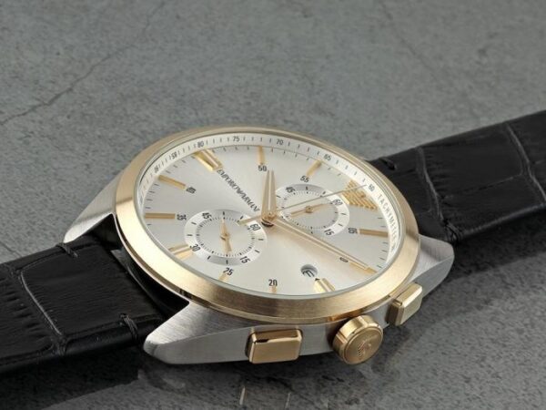 Emporio Armani Claudio chronograph on wrist showing white dial with gold accents and black leather strap