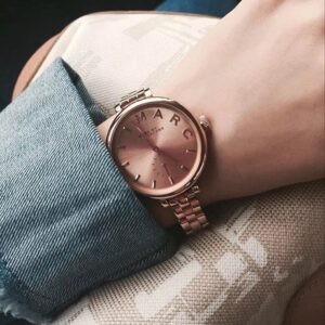 Marc Jacobs Sally rose gold watch MBM3364 on wrist with blue sleeve