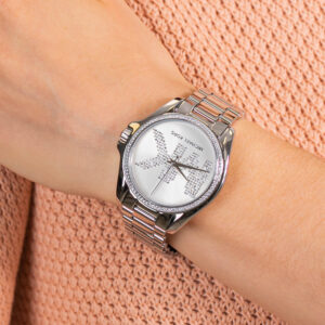 Michael Kors Bradshaw silver-tone watch worn on wrist against peach-colored textile
