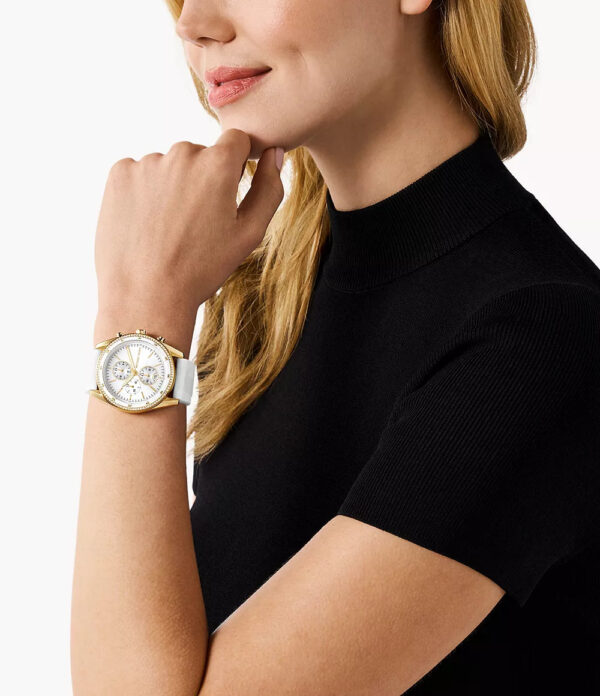 Michael Kors Hadyn MK7484 gold chronograph watch worn on wrist with white strap