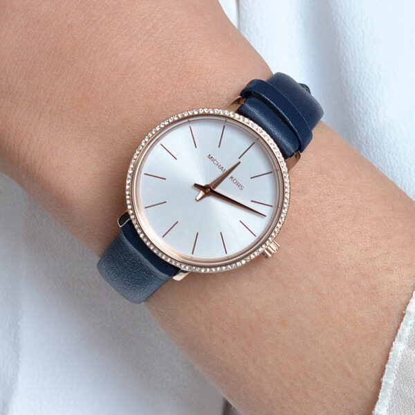 Michael Kors Pyper watch worn on wrist showing white dial with rose gold hands and indices