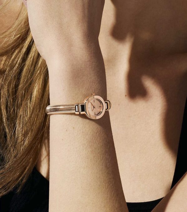 Michael Kors Mini Gramercy rose gold watch worn on wrist with textured bangle bracelet