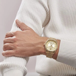 Michael Kors Lexington gold watch on wrist with cream sweater