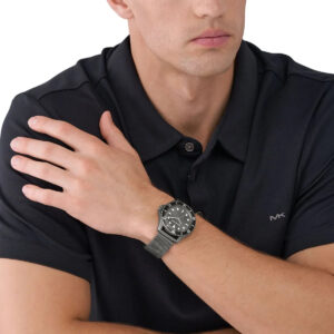 Michael Kors Everest gunmetal watch worn on man's wrist with black polo