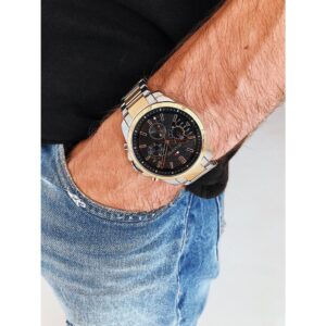 Tommy Hilfiger dual-tone men's chronograph watch worn on wrist with denim and black sleeve