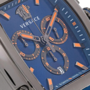 Close-up of Versace Dominus blue dial with orange chronograph subdials, hour markers, and Versace logo