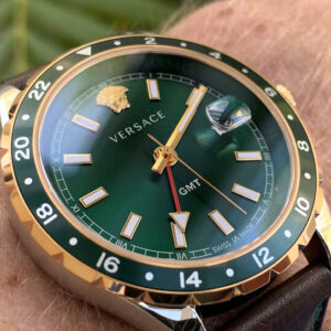 Versace Hellenyium watch on wrist showing green dial, gold and silver case, and GMT hand